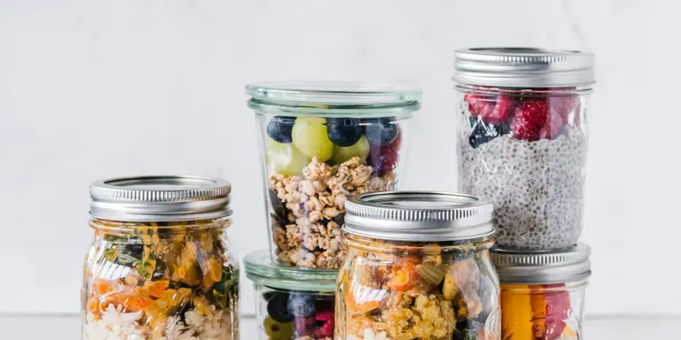 Bocaux en verre remplis de repas préparés à l'avance, riz, granola et fruits frais