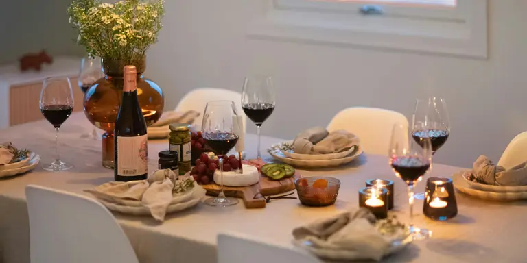 Table dressée pour un dîner à la maison avec des plats préparés et des verres de vin